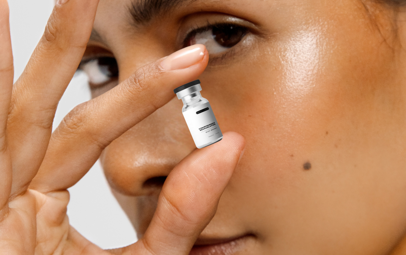 small medical vial a woman is holding with her face is the background