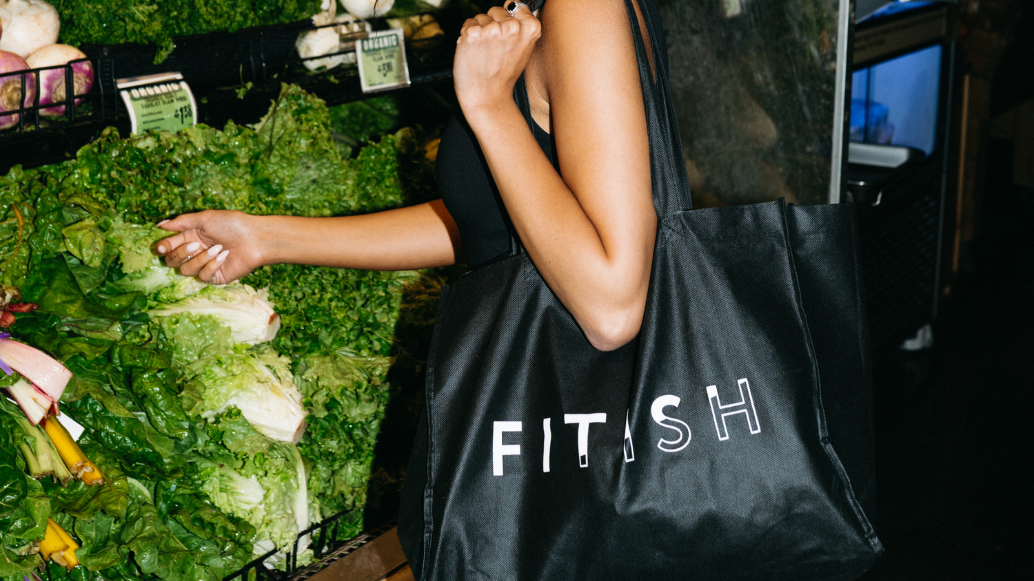 Fitish branded tote bag filled with fresh groceries in the produce section, highlighting healthy shopping, wellness lifestyle, and the Fitish 30 Challenge grocery list.