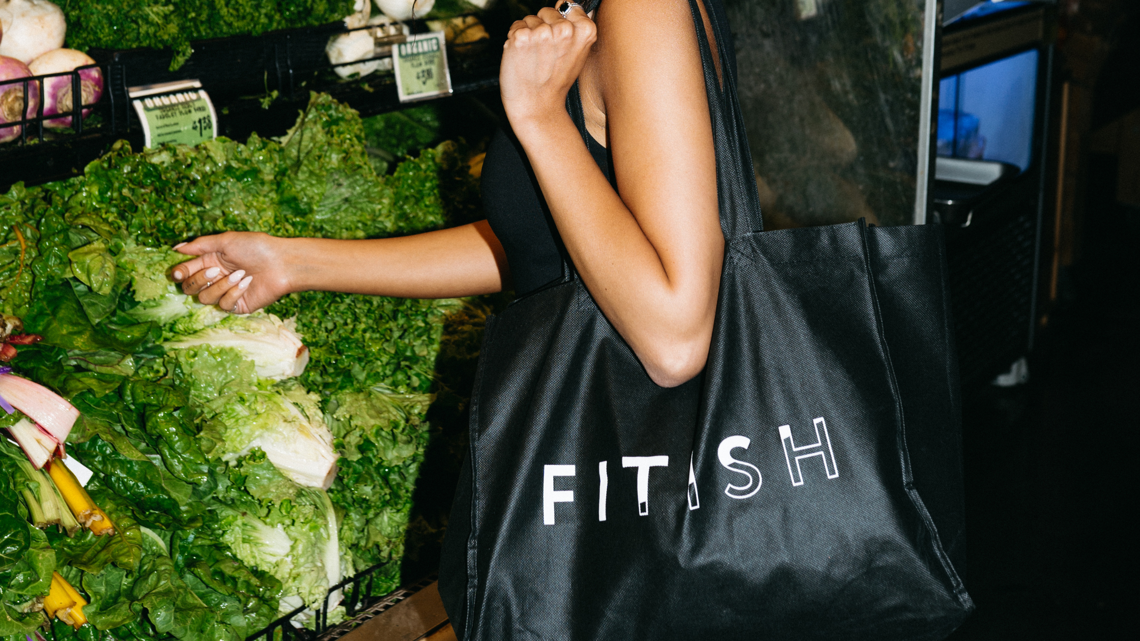 Fitish branded tote bag filled with fresh groceries in the produce section, highlighting healthy shopping, wellness lifestyle, and the Fitish 30 Challenge grocery list.
