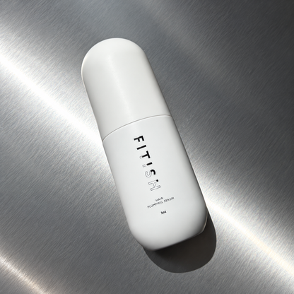 Fitish Hair Plumping Serum 3 oz capsule bottle lying on brushed steel