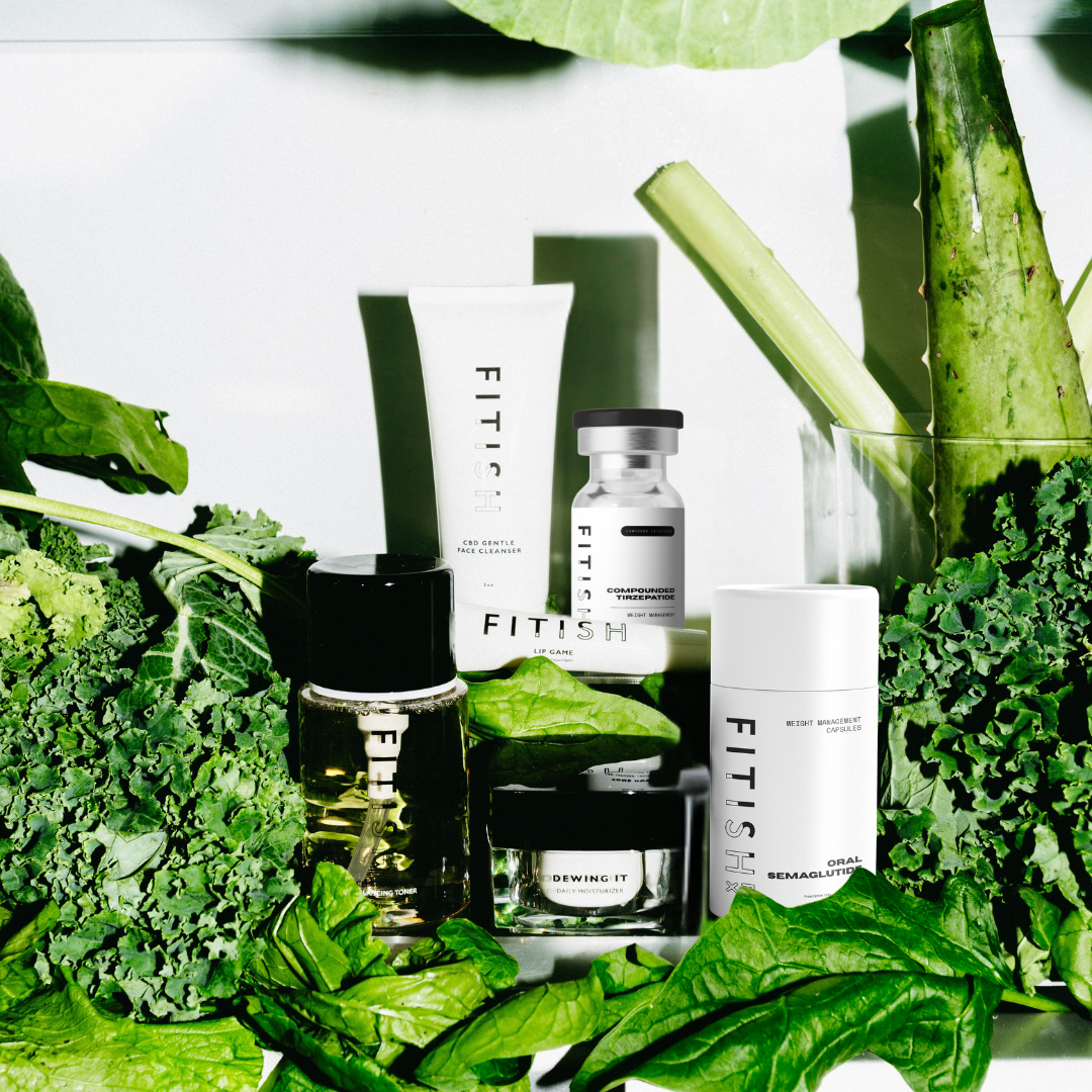 Fitish skincare and wellness products including Dewing It Moisturizer, CBD Gentle Face Cleanser, Clear Winner Toner, Night Game Serum, and Fitish RX compounded tirzepatide and oral semaglutide surrounded by fresh greens, representing holistic wellness and science-backed skincare.